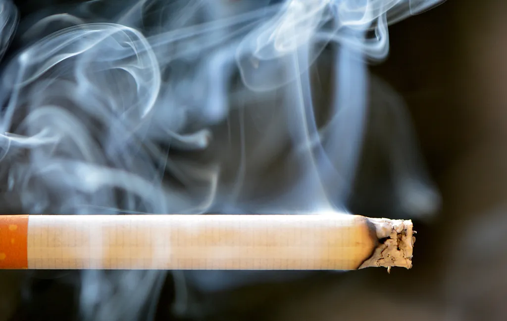 brinnande cigarett som visar mycket rök som kan skada din lägenhet